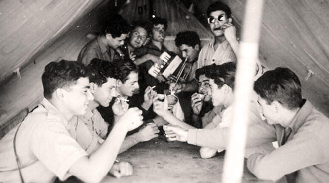 חברים בניר עם חוגגים בתוך אוהל, בשנים הראשונות לקיומו (צילום: נדב מן, ביתמונה. מאוסף שפרה שוורץ, האוסף הלאומי לתצלומים על שם משפחת פריצקר, הספרייה הלאומית) חברים בניר עם חוגגים בתוך אוהל, בשנים הראשונות לקיומו