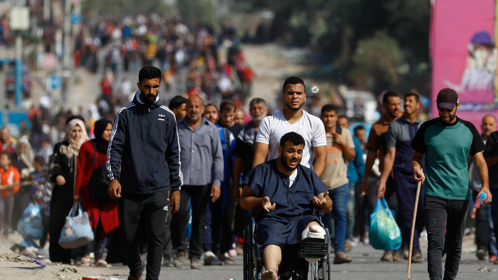 Residents of northern Gaza move south via the humanitarian corridor (Photo: Ibraheem Abu Mustafa / Reuters) פלסטינים עוזרים את צפון הרצועה דרומה