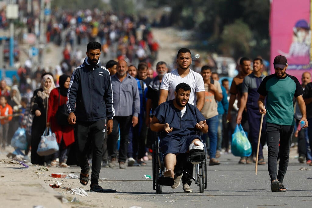 Photo: REUTERS/Ibraheem Abu Mustafa פלסטינים עוזרים את צפון הרצועה דרומה