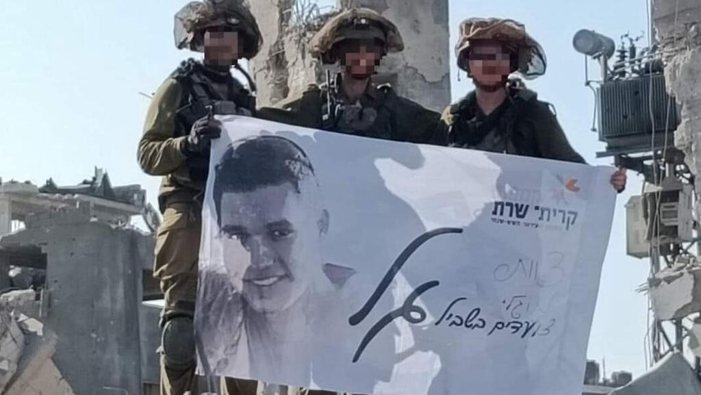 חבריו של גל בסון מניפים את הדגל בבית חאנון. "הוא תמיד איתנו בלב" (צילום: דובר צה"ל ) חברי צוות מוגלי ביהל"ם, שאיבדו את חברם גל בסון בצוק איתן, הניפו דגל עם שמו ותמונתו