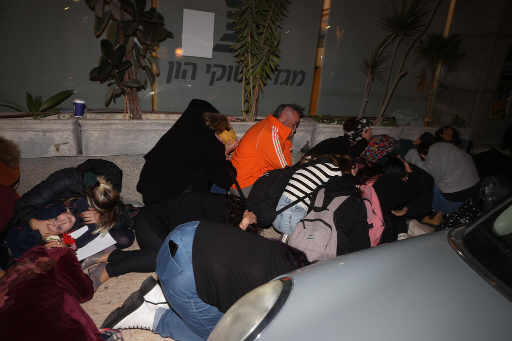 תופסים מחסה מול משרדי יוניסף בתל אביב בזמן אזעקה