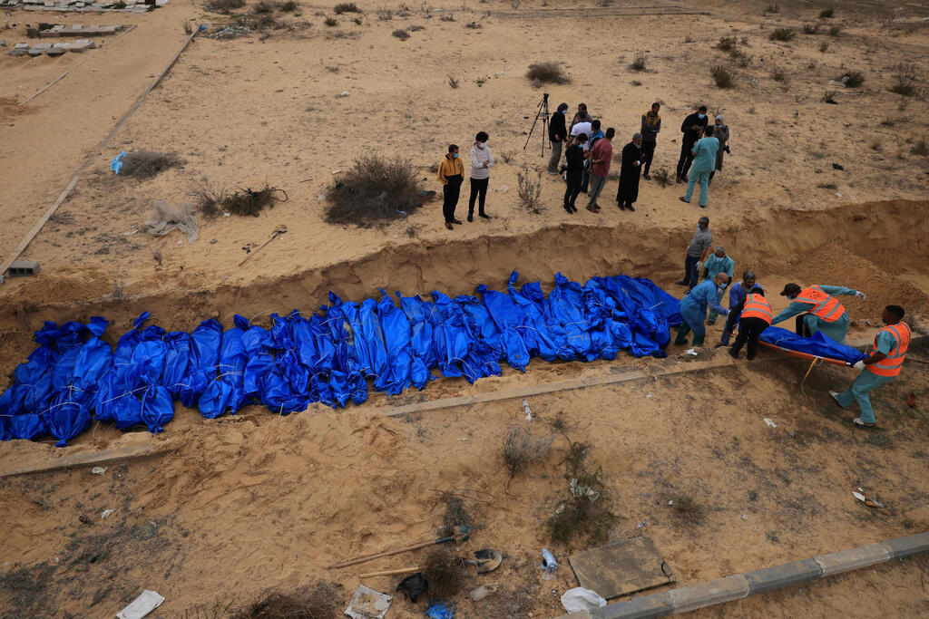 צילום: Mahmud HAMS / AFP קבר אחים בחאן יונס