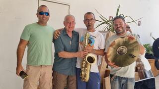 עוזי בארי מחלק כלי נגינה בים המלח. מימין: חגי ביקל, אור לב, בארי ומעין ברק