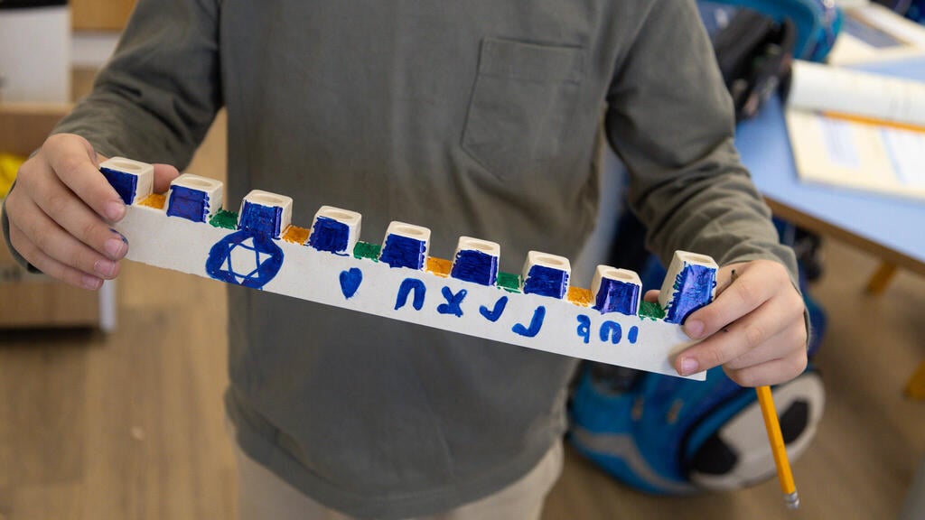 IDF soldiers lit menorah's in Gaza decorated by evacuee children (Photo: IDF Spokesperson's Unit) לוחמי צה"ל מדליקים נרות בתוך שטח רצועות עזה, עם חנוכיות שקושטו על ידי חברי הקהילות המפונות