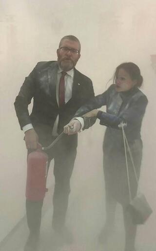 Far-right Polish lawmaker Grzegorz Braun uses a fire extinguisher to put out Hanukkah candles lit in Poland's Parliament