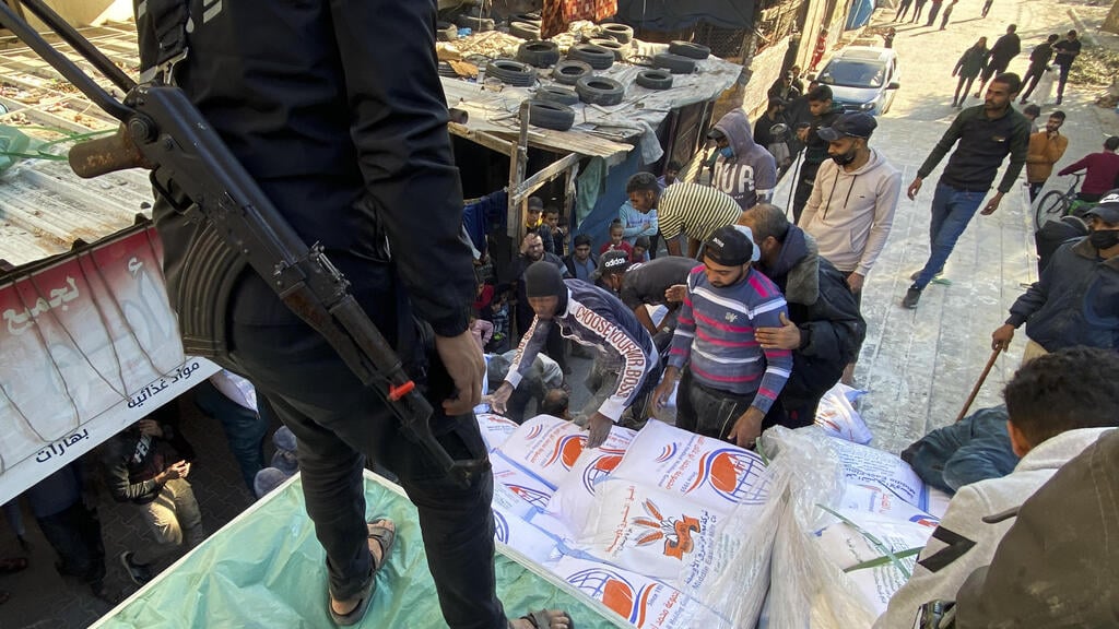 Hamas operative oversees delivery of aid in Rafah (Photo: AP) מחבלי חמאס על משאית חיטה של סיוע הומניטרי