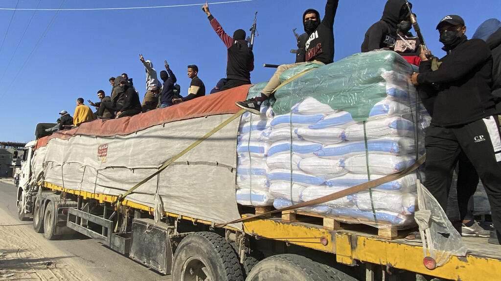 Hamas terrorists after they took over a truck delivering aid to Gaza (Photo: AP) מחבלי חמאס על משאית חיטה של סיוע הומניטרי