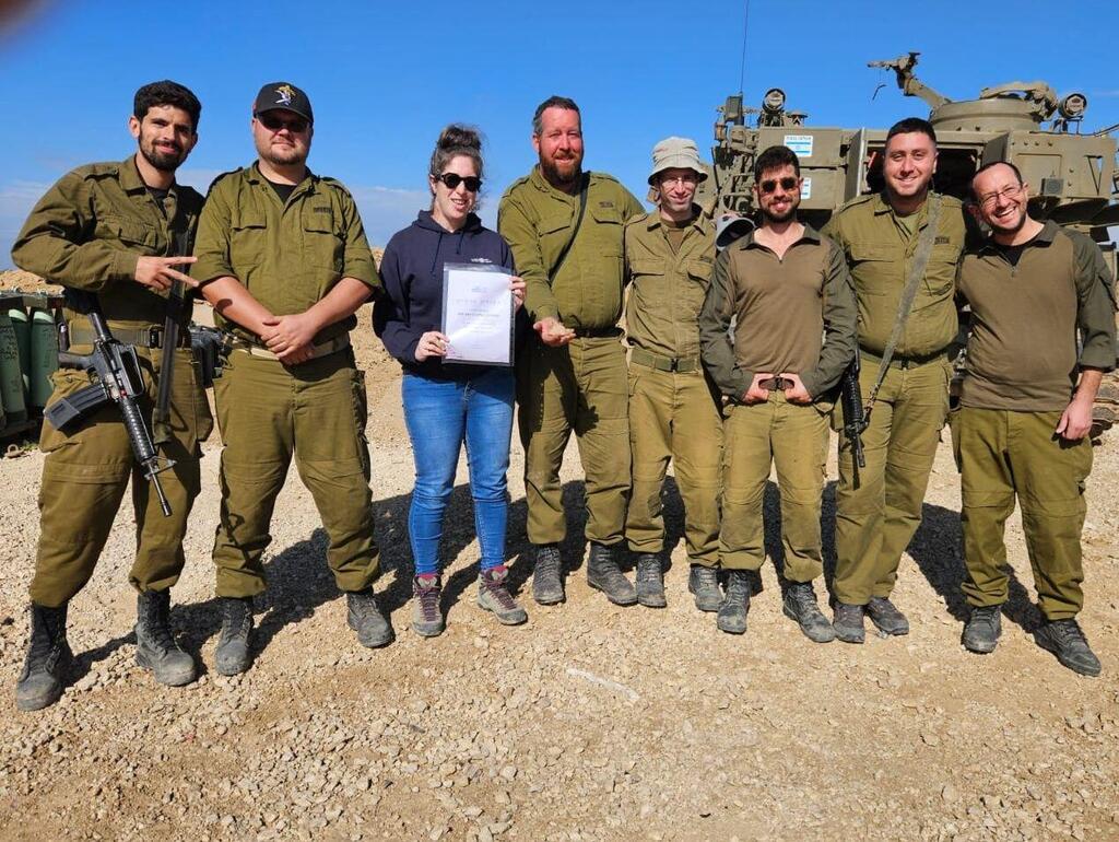 שרה טל מרשות העתיקות עם החיילים ותעודת ההוקרה שקיבלו