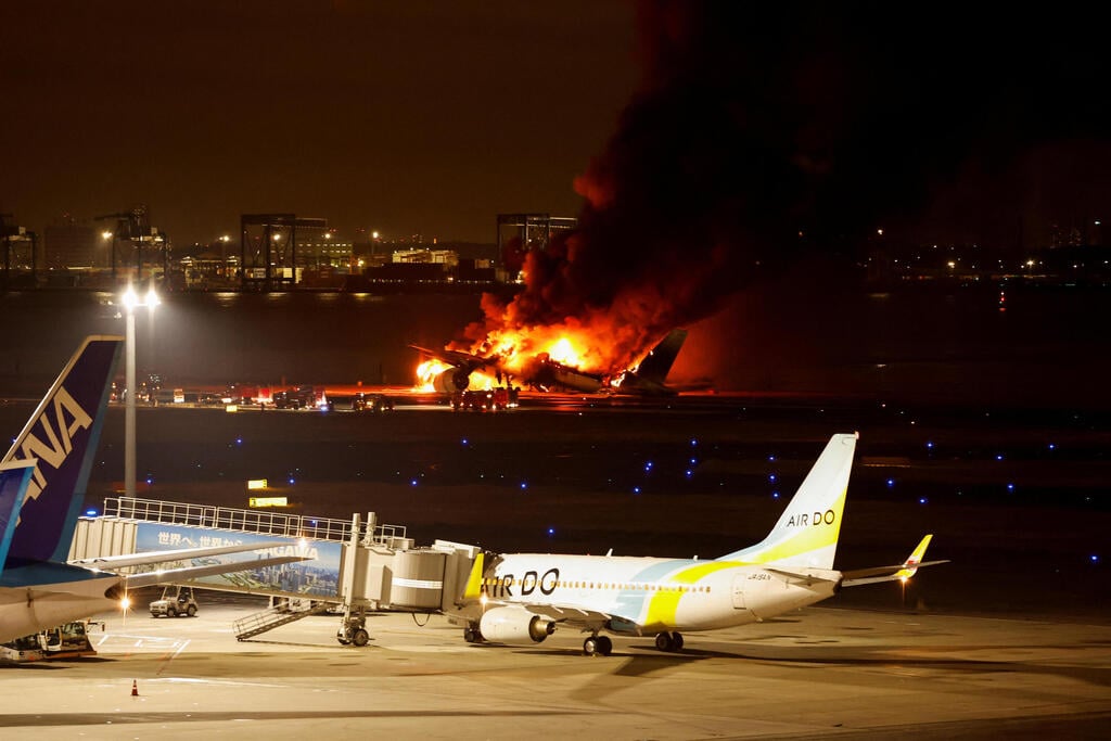 צילום: REUTERS/Issei Kato מטוס יפני עולה באש