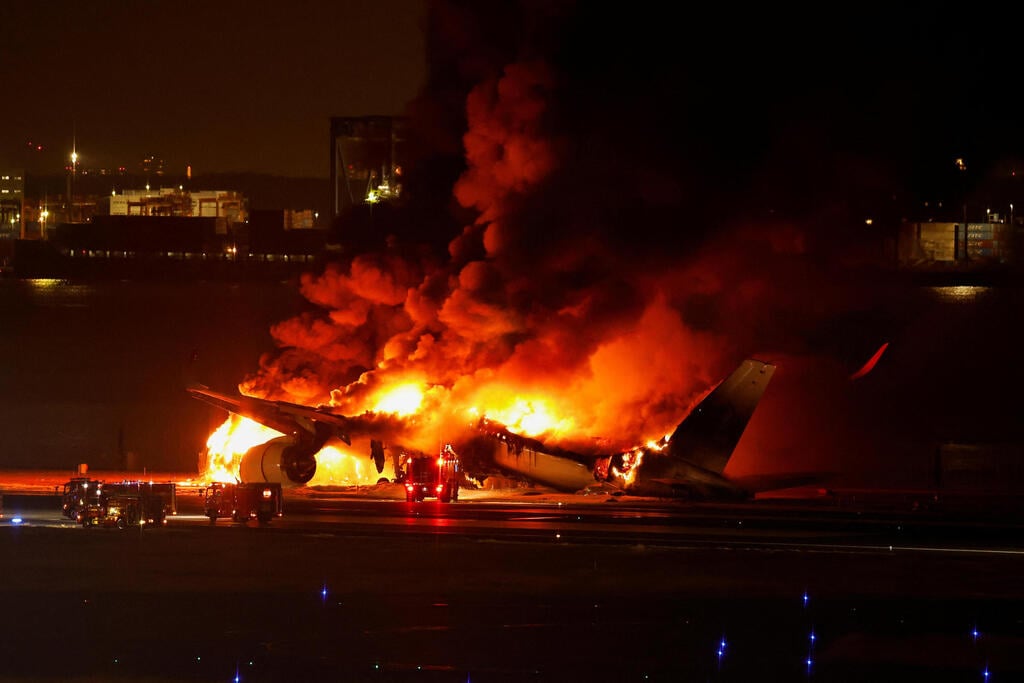 צילום: REUTERS/Issei Kato מטוס יפני עולה באש