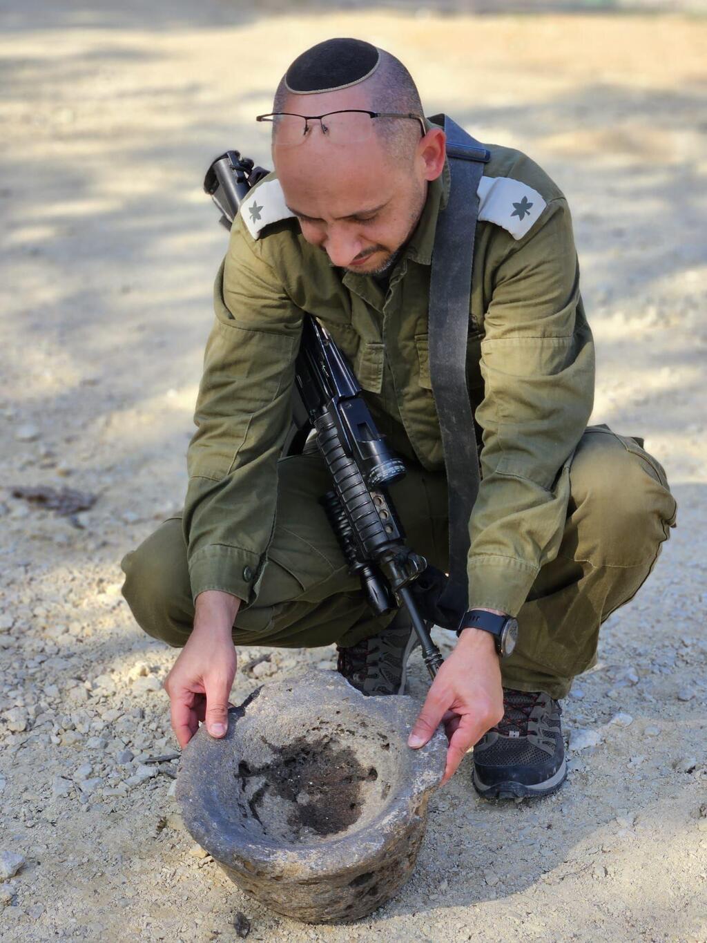 Maj. Eliashiv Bohbut with the millstone (Photo: Yair Amizur, Israel Antiquities Authority) רס"ן במיל' אלישיב בוחבוט עם המכתש