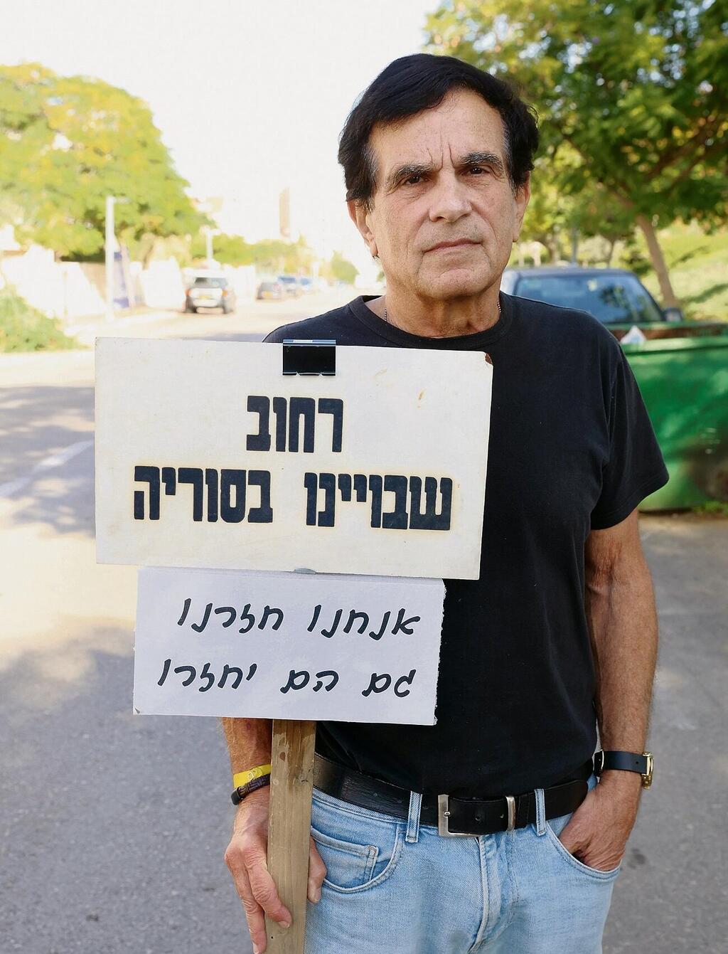 עידו גולדהכט עם השלט "אנחנו חזרנו, גם הם יחזרו"