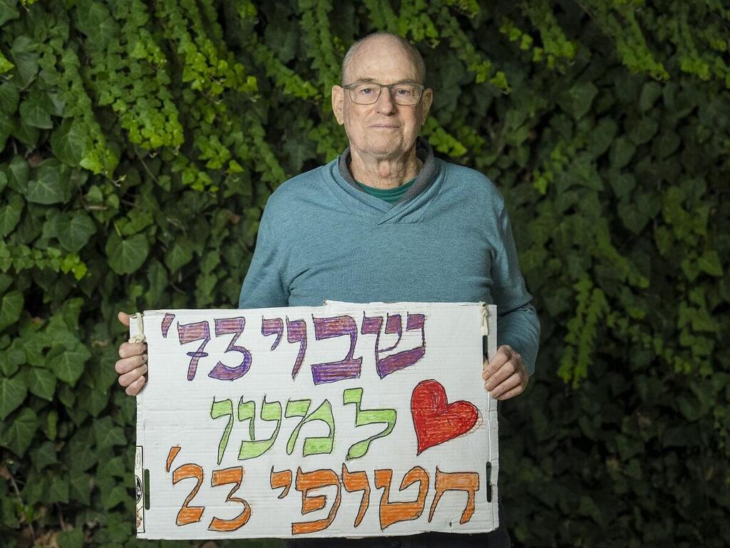 משה (מוסא) מנחם עם שלט תמיכה במשפחות החטופים