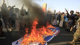 Houthis burn the American and Israeli flags in protest of the U.S. attack on Houthi targets 