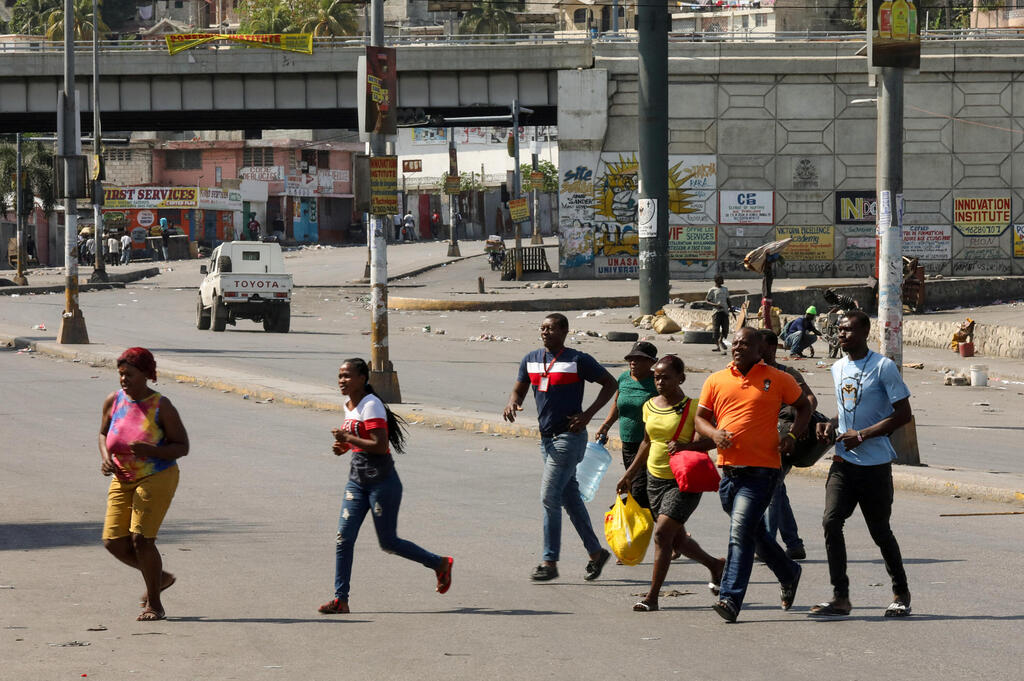 בורחים מאזורי הקרבות בפורט או-פרינס. וושינגטון רוצה "להחיש את חילופי השלטון" (צילום: REUTERS/Ralph Tedy Erol) האיטי פורט או פרינס בורחים מקרבות כנופיות פשע