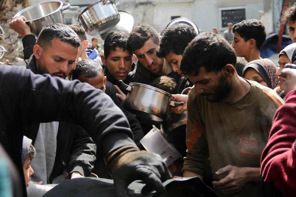 פלסטינים מתאספים לקבל מזון בג'באליה (צילום: REUTERS/Mahmoud Issa) פלסטינים מתאספים לקבל מזון בג'באליה