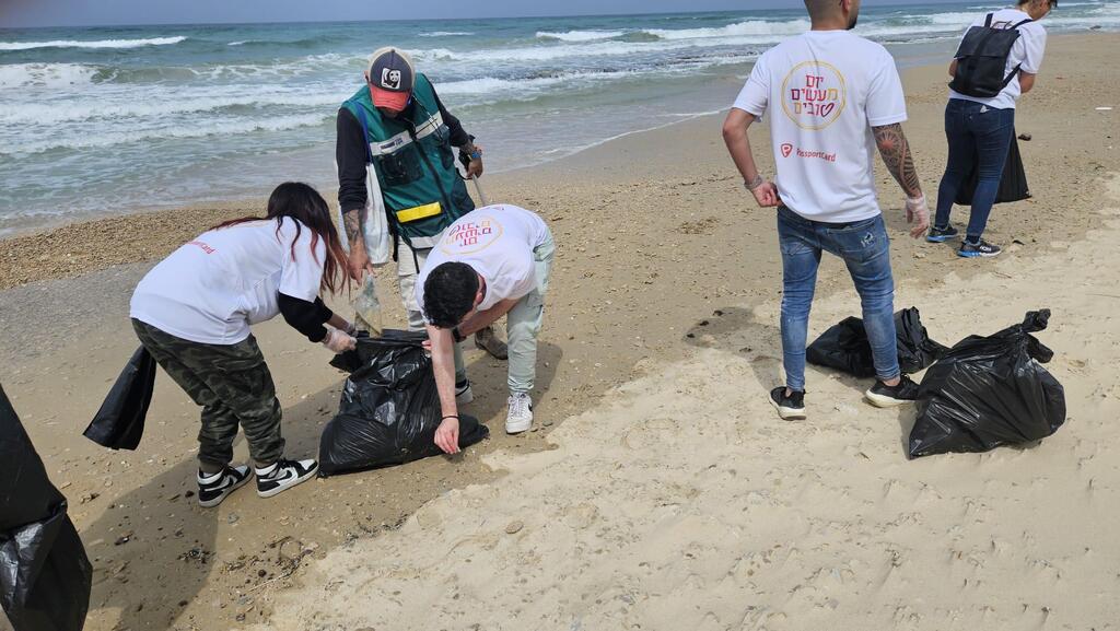  עובדי פספורט כארד יחד עם אקואושן מנקים את החוף