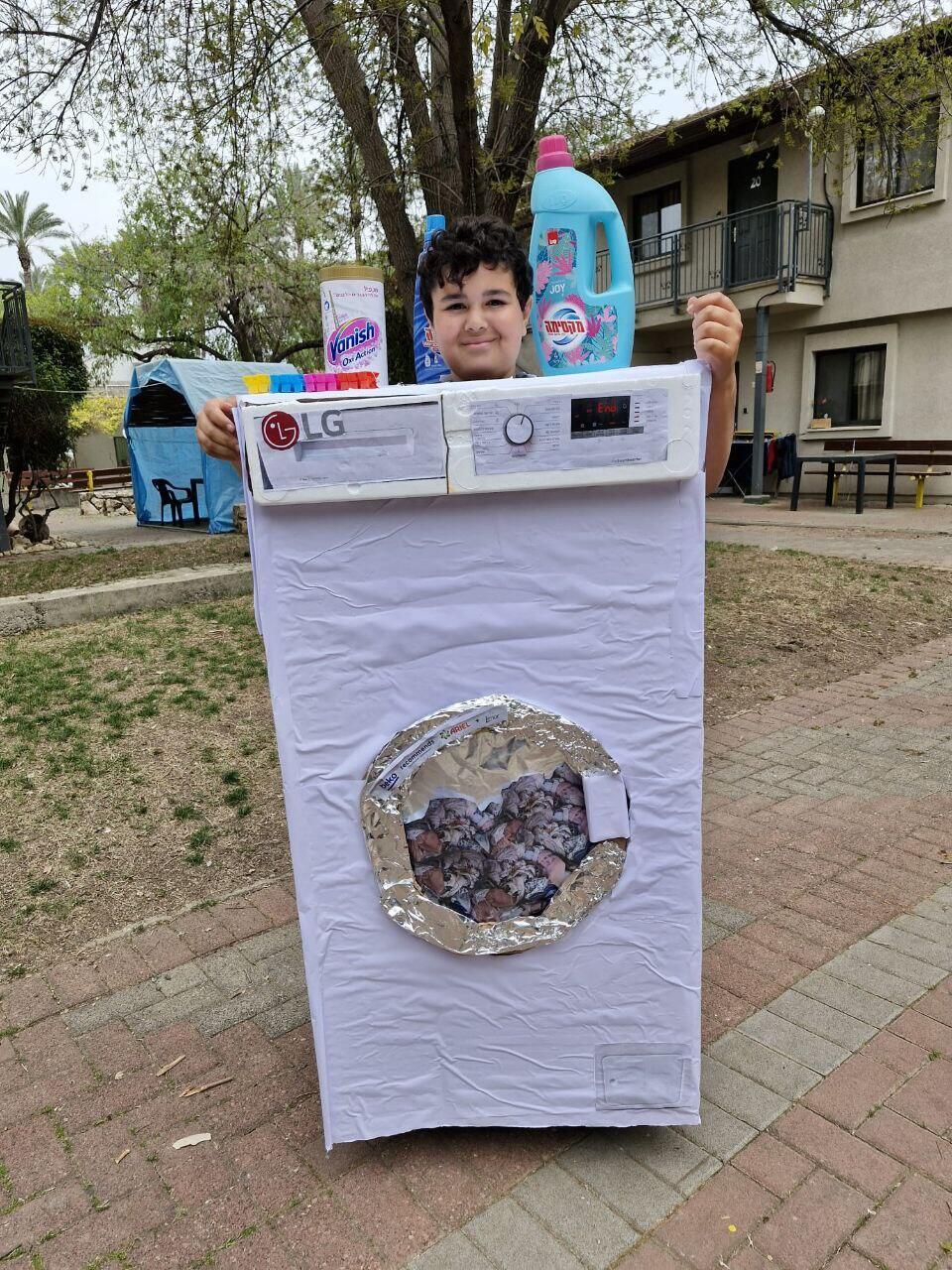 ילדים שפונו מהצפון מחופשים. אחד מהם התחפש למכונת כביסה, מכשיר חיוני שחסר לרבים מהם ילדים שפונו מהצפון מחופשים