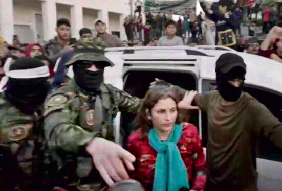 מוקפת באנשי חמאס ביום חזרתה הביתה לישראל yk13857737