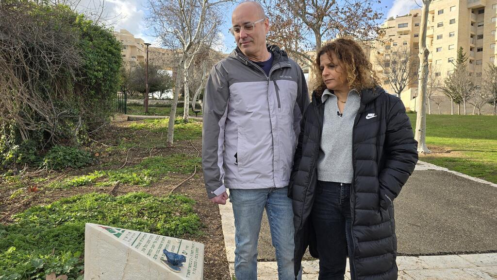 ההורים ליד אבן ההנצחה, שעליה מישהו השאיר ציפור כחולה. "להנצחה פה בשכונה יש משמעות" (צילום: שמוליק דודפור) ליאור וענת גלס ליד אבן ההנצחה
