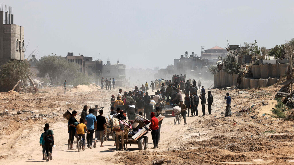 Palestinians in Gaza (Photo: AFP) פלסטינים עושים את דרכם חזרה לחאן יונס