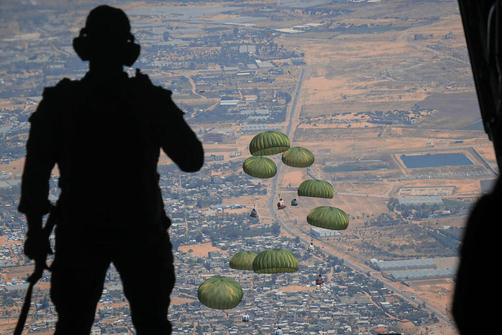 Jordanian soldier looks on as humanitarian aid airdropped over Gaza (Photo: AFP PHOTO / JORDANIAN ARMY) סיוע הומניטרי מוצנח ממטוס ירדני מעל עזה