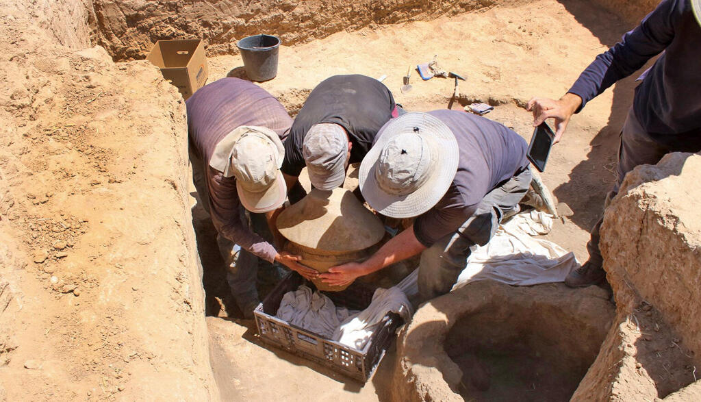 כלי השנהב השבור הוטמן בתוך קערות בזלת גדולות. חילוץ הקערות (צילום: דוידה דגן, רשות העתיקות) כלי השנהב השבור הוטמן בתוך קערות בזלת גדולות. חילוץ הקערות
