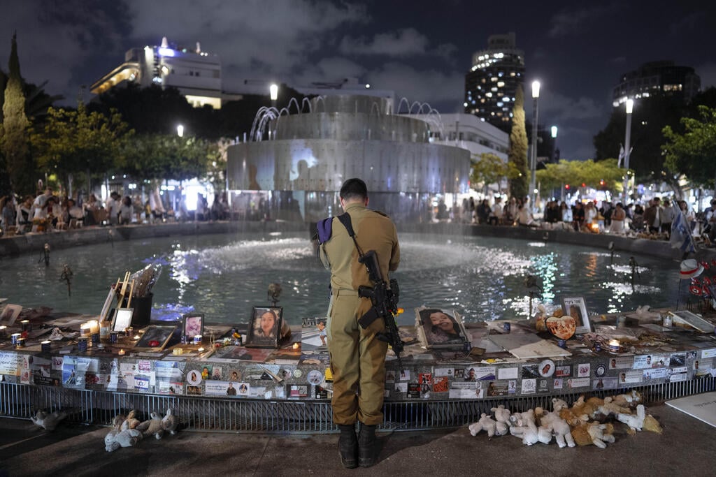 צילום : AP /Oded Balilty אנשים עומדים בצפירה בכיכר דיזינגוף תל אביב