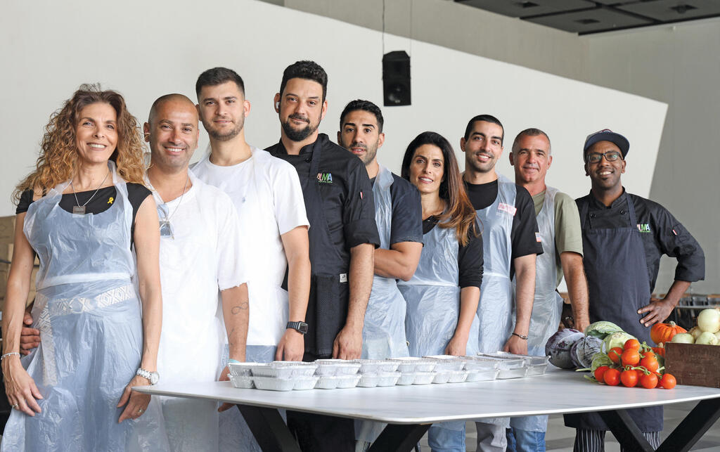 קרן בן אהרון (רביעית מימין) וצוות המתנדבים במטבח | צילום: אביגיל עוזי yk13916923