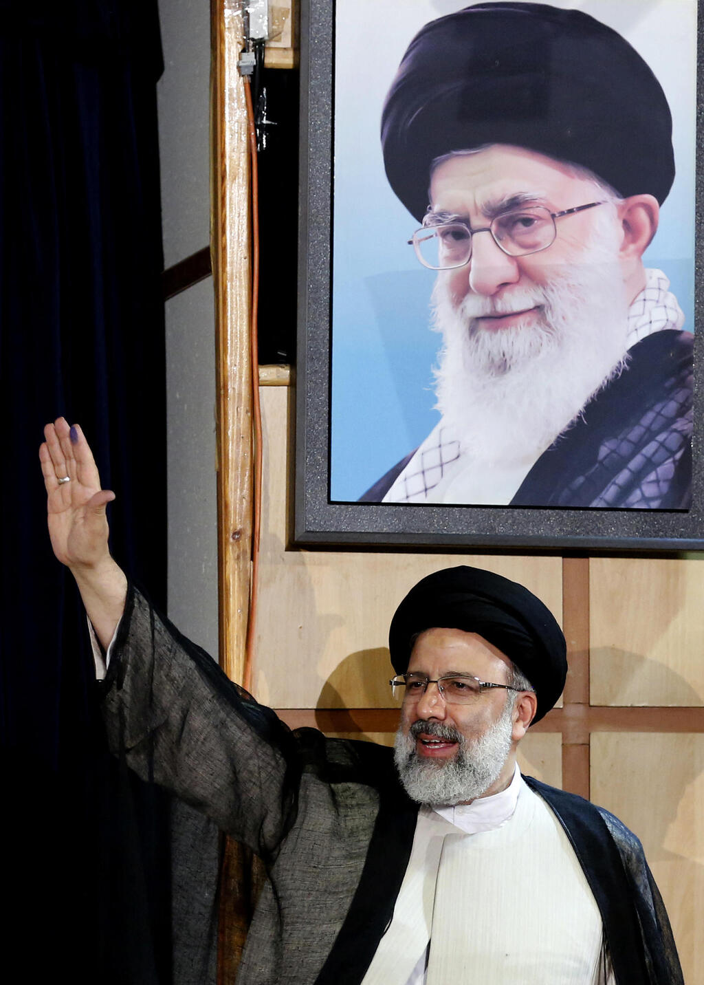 Iranian President Ebrahim Raisi under a portrait of Supreme Leader Ayatollah Ali Khamenei (Photo: ATTA KENARE / AFP) נשיא איראן שנהרג ב התרסקות איבראהים ראיסי לצד תמונת המנהיג העליון חמינאי בשדנת 2017 - כשראיסי התמודד אז (ונכשל) בבחירות לנשיאות