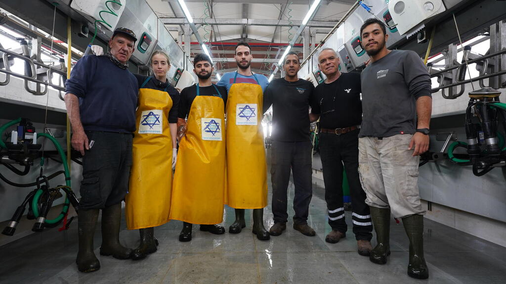 צוות הרפת של עלומים עם הרפתנים והמתנדבים כיום. "בשיאו של תהליך שיקום" (צילום: אורי לבני, שוקי דקל) צוות הרפת של עלומים עם הרפתנים והמתנדבים, אחרי ה-7 באוקטובר