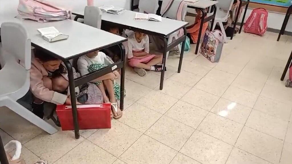 תלמידות בבית ספר בשדרות מתחבאות מתחת לשולחנות בזמן צבע אדום
תלמידים בבית ספר בשדרות מתחבאים מתחת לשולחנות בזמן צבע אדום