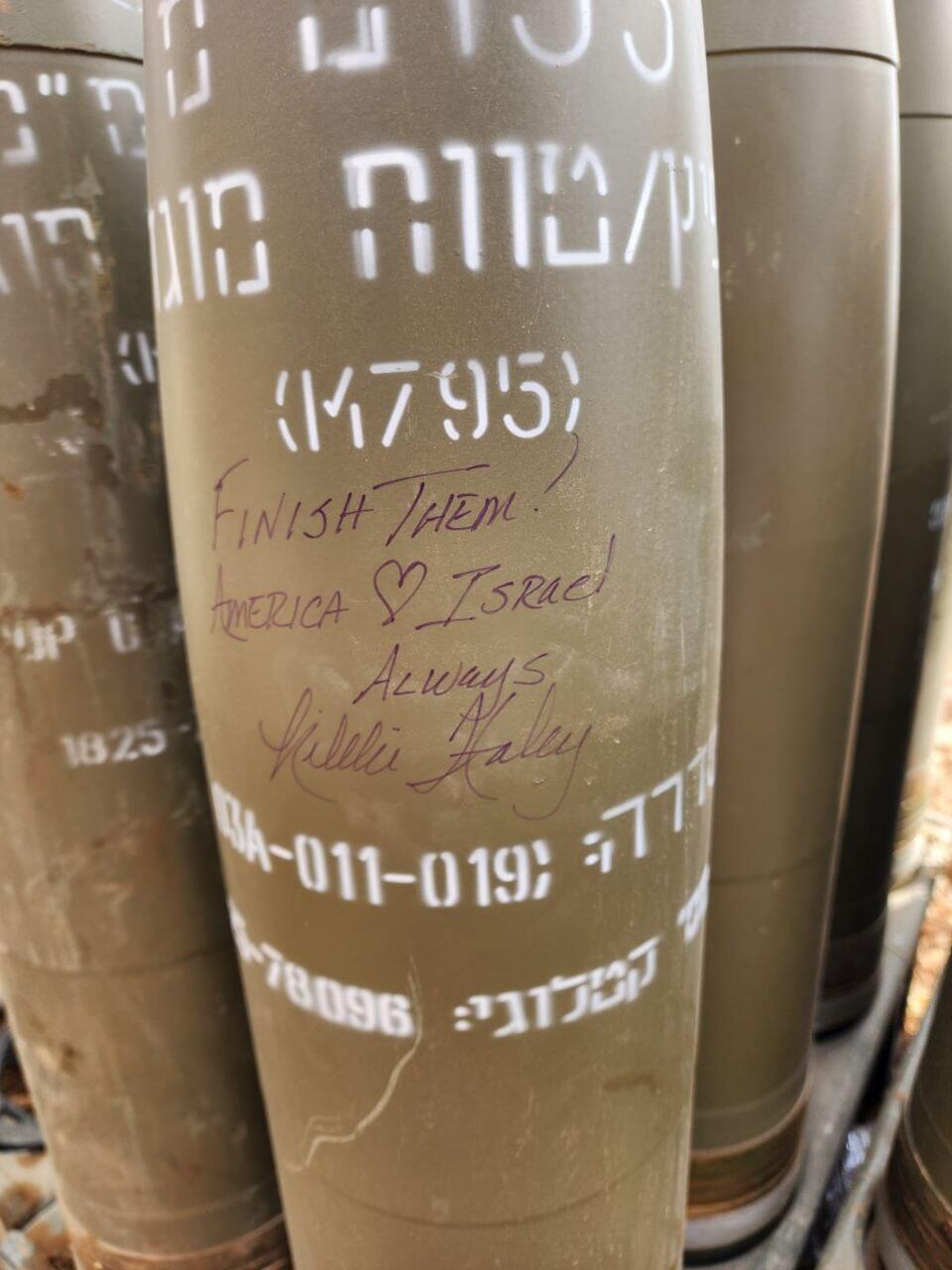 Niki Haley signs a shell at an artillery battery in northern Israel ביקורה של ניקי היילי בסוללת התותחנים ובראש הנקרה