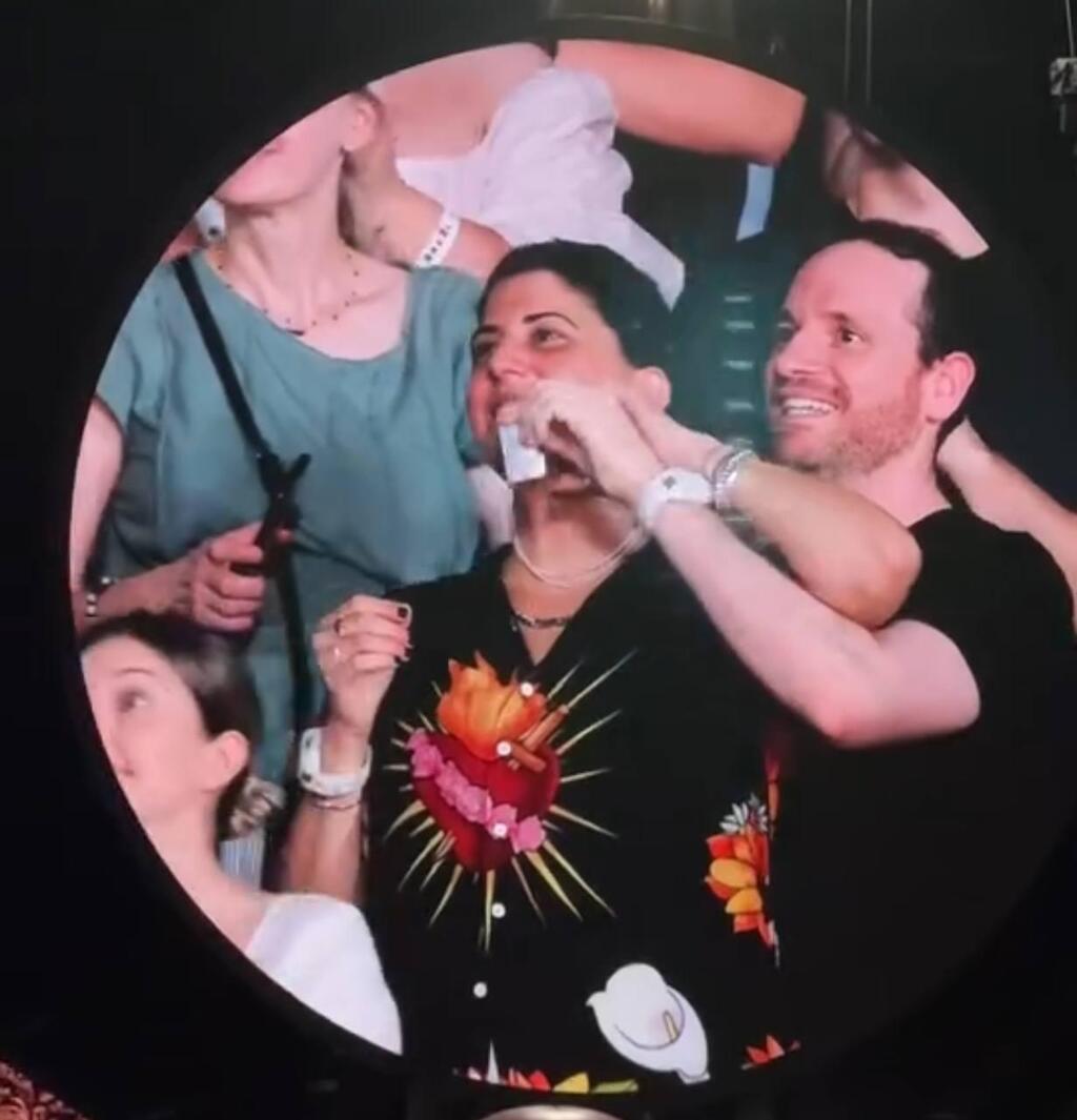 Member of the crowd displays hostage dog tag at Coldplay concert in Bucharest (Photo: Priel Schneiderman) מרטין ביקש להתמקד. האישה מציגה את הדיסקית