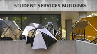 Pro-Palestinian student protesters barricade the entrance to the student services building 