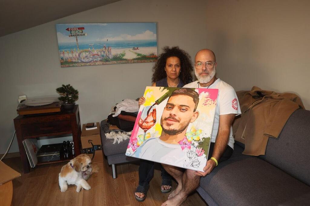 ניבה ושי ונקרט עם תמונתו של עומר. "קורס יין כשיחזור" (צילום: יריב כץ) משפחתו של עומר ונקרט החטוף
