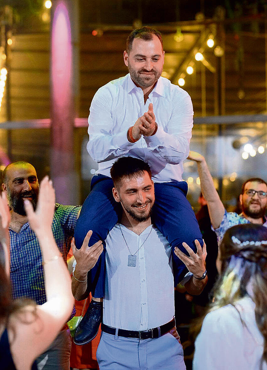 Szneiberg carries Atlow at his real wedding after rehabilitation (Photo: Guy Barda) אור שנייברג, ישראל אטלו