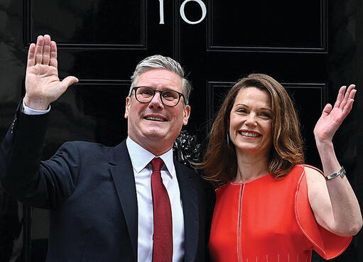 בשמלה אדומה ובלי פוזות. ויקטוריה וקיר סטארמר בכניסה למעון | צילום: AFP yk13991546