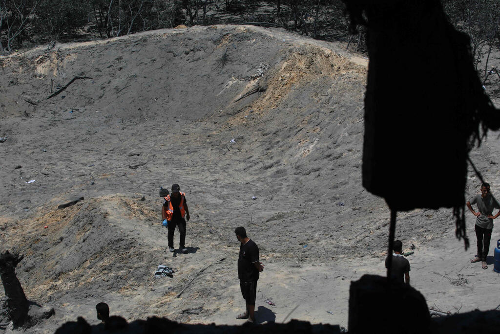 צילום: Bashar TALEB / AFP המכתש שנוצר בעקבות התקיפה בחאן יונס