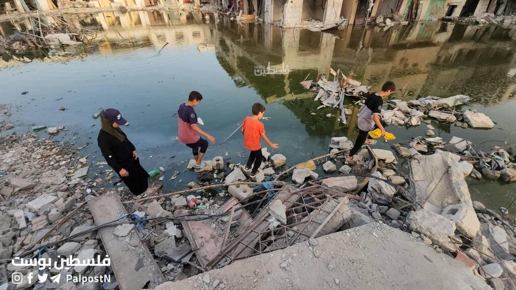 Kids walking in open sewage in Khan Younis ביוב זורם חאן יונס רצועת עזה