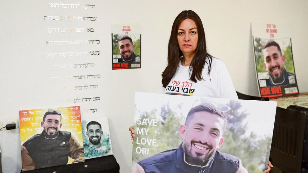 "אני מאמינה שהוא לא דואג לעצמו כמו שהוא דואג לי". עינב דנינו מחזיקה את תמונת בנה החטוף yk14009044