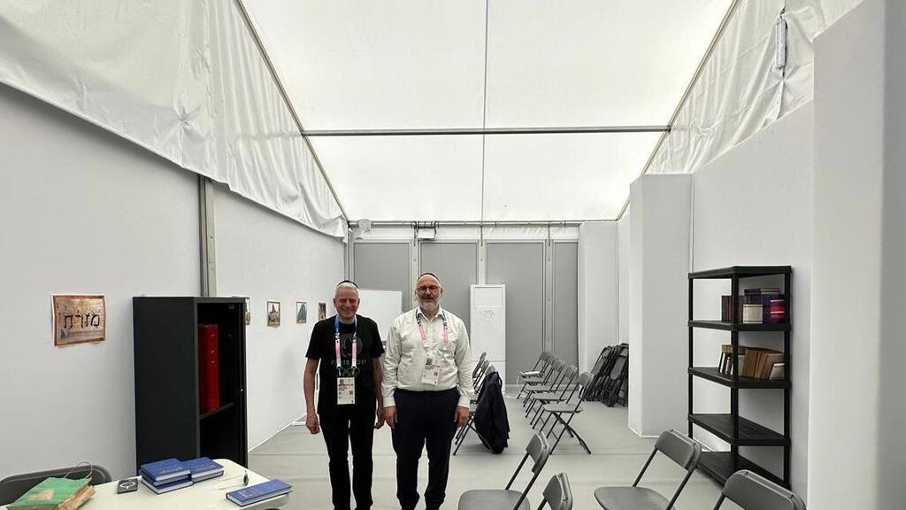 The new synagogue at the Olympic Village (Photo: Conference of European Rabbis) הרב משה לוין (משמאל, בשחור) לצד הרב לורן שלום ברוס מהקהילה היהודית, בבית הכנסת שהוקם בכפר האולימפי