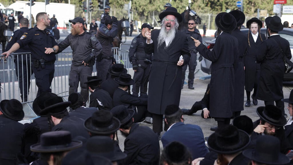 חרדים יושבים על הרצפה ליד לשכת הגיוס (צילום: REUTERS/Ricardo Moraes) חרדים מפגינים בלשכת הגיוס בתל השומר