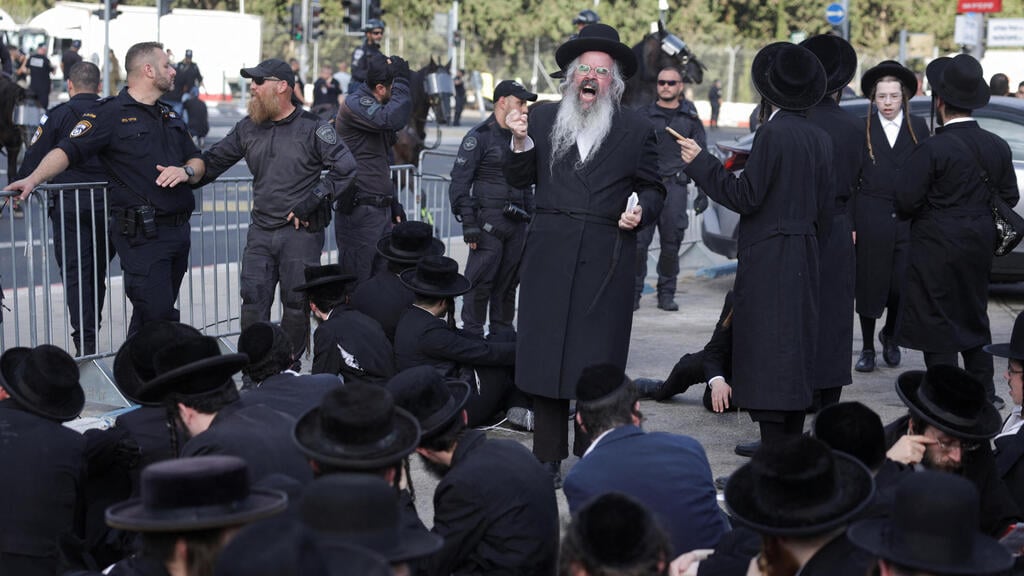 חרדים יושבים על הרצפה ליד לשכת הגיוס (צילום: REUTERS/Ricardo Moraes) חרדים מפגינים בלשכת הגיוס בתל השומר