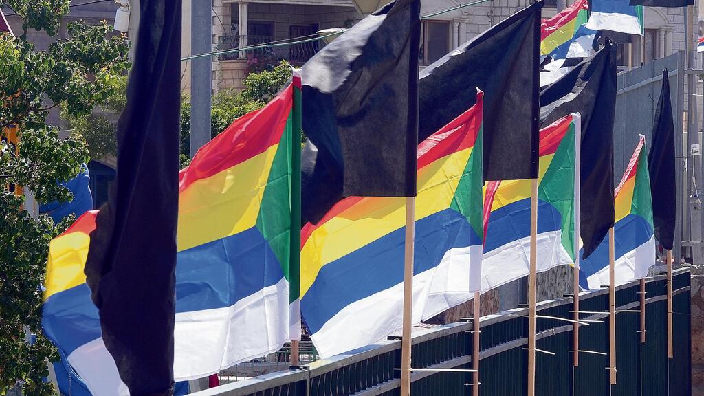 דגלי אבל במג'דל שמס. "מצד אחד מכלילים את הדרוזים, ואז מדירים אותם עם חוק הלאום וחוק קמיניץ. אלה תהליכים שגדולים על הפרט" (צילום: אפי שריר) דגלים שחורים לצד דגלי העדה הדרוזית במג'דל שמס