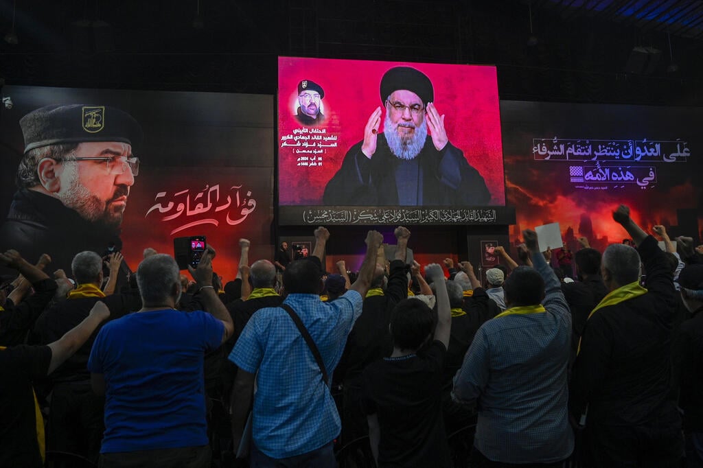 Hezbollah leader Hassan Nasrallah speaks before his followers in Beirut's Dahieh district (Photo: EPA/WAEL HAMZEH) צופים בנאום של נסראללה בביירות