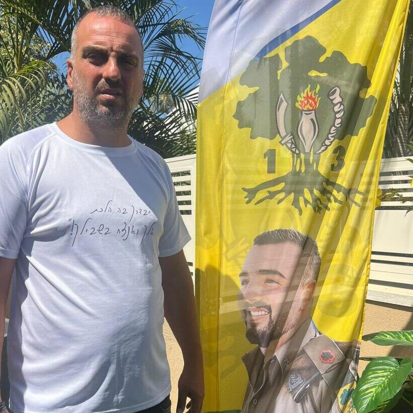 רוני פרץ לצד דגל גולני עם איור של בנו, רז ז"ל (צילום: באדיבות המשפחה ) איתמר פרץ ומשפחתו אחרי סיום המסלול