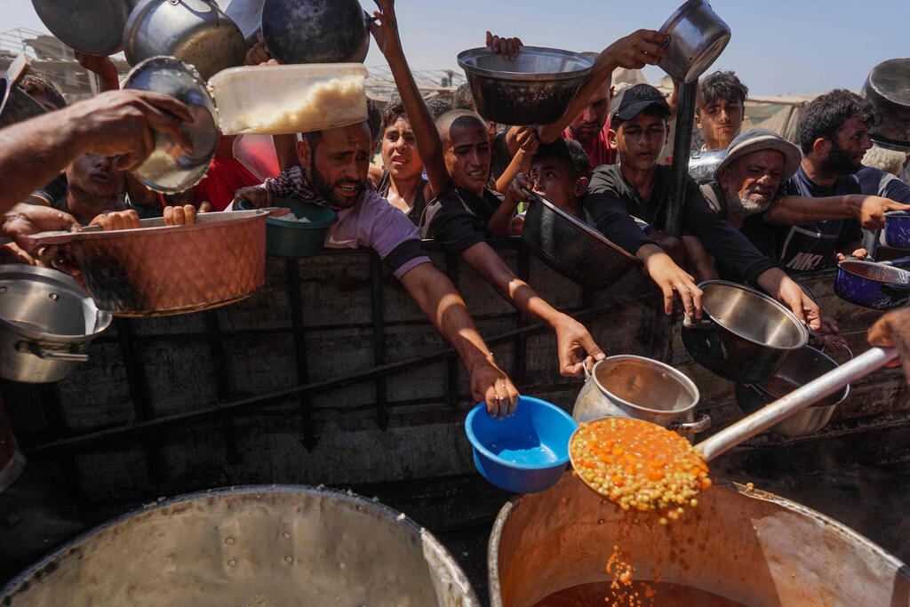 "99% מהסוחרים קובעים מחיר לבד" (צילום: Bashar TALEB / AFP) מחלקים אוכל בעזה