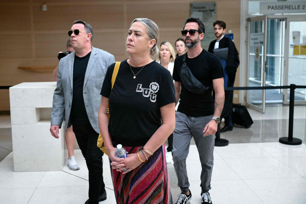 שניים משלושת ילדיהם של בני הזוג, פלוריאן (מימין) וקרולין (במרכז), מלווים את אמם הבוקר בבית המשפט (צילום: Christophe SIMON / AFP) צרפת ג'יזל פליקו משפט של בעלה ש סימם ו אנס אותה עם עשרות גברים שניים מ ילדיה מימין פלוריאן במרכז קרולין