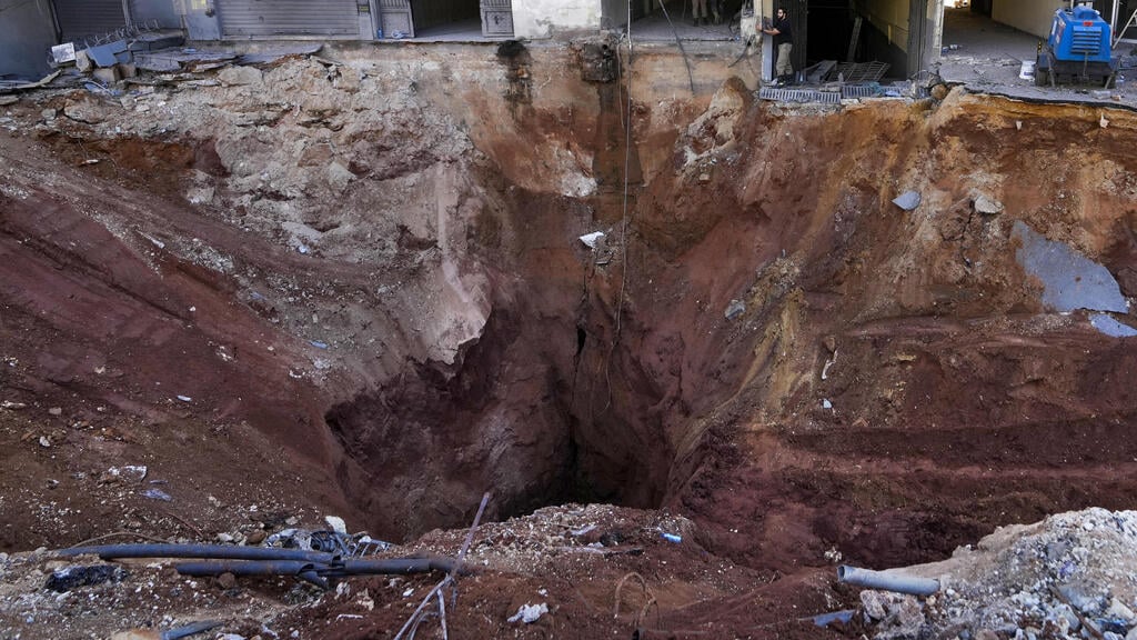 מכתש שנוצר בזירת התקיפה בדאחייה (צילום: AP Photo/Hassan Ammar) הריסות בביירות